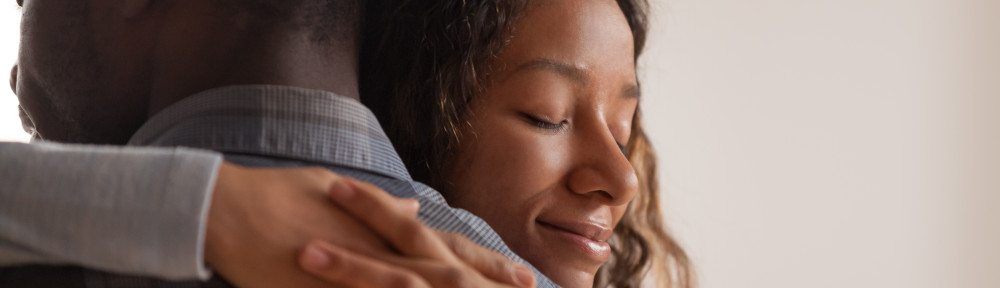 Close up black African wife embracing husband