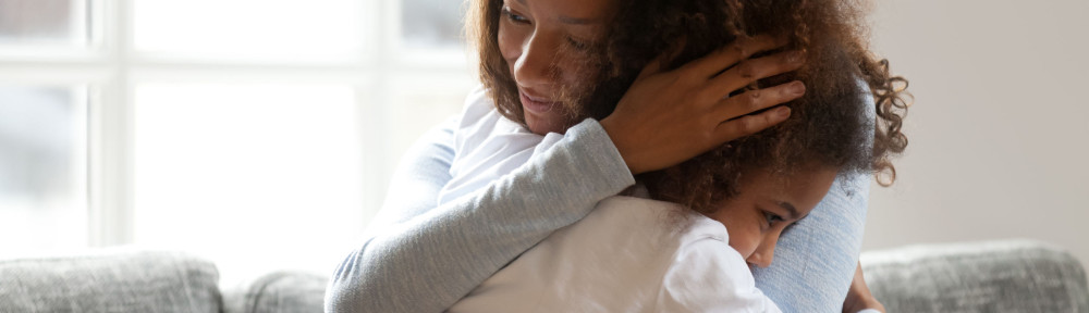 Loving single black mother hugging african daughter caressing cu
