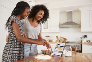 Teenage Girls Following Recipe On Digital Tablet