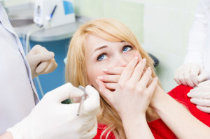 Female patient in dentist office afraid of doctor, procedure