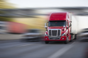 Bright red modern big rig semi truck with semi trailer move with