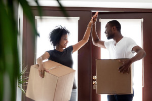 Happy african couple giving high five celebrating moving day