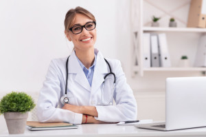 Female Physician Smiling Looking At Camera Sitting In Office