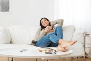 Smiling woman thinking on sofa