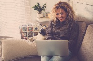 beautiful blonde curly woman working at home with a laptop inter