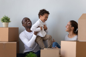 Happy laughing african american young man rising up joyful son.