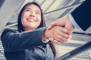 Smiling businesswoman making handshake with a businessman