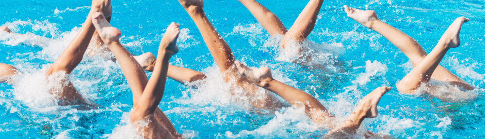 61042573 - synchronized swimmers performance with legs outside water