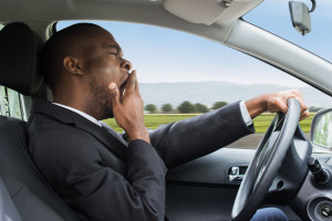 Businessman Yawning While Driving Car