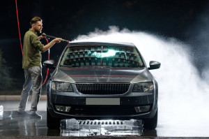 Car close-up. Car wash. Manual car wash with pressurized water in car wash outside.