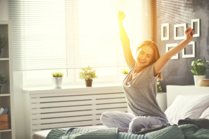 young   woman woke up in the morning in the bedroom by the window with her back