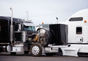 Big rig black semi truck tractor with open hood prepare engine t