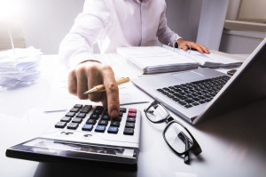 Businessman Calculating Tax Using Calculator