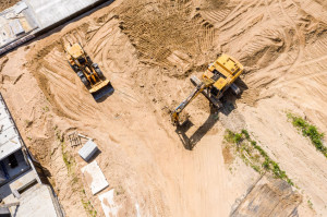 aerial top view of yellow industrial heavy machines moving groun