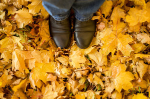 Fall, autumn, leaves, legs and shoes. Conceptual image of legs in boots on the autumn leaves.