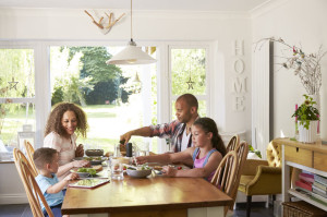 Family At Home Eating Meal In Kitchen Together