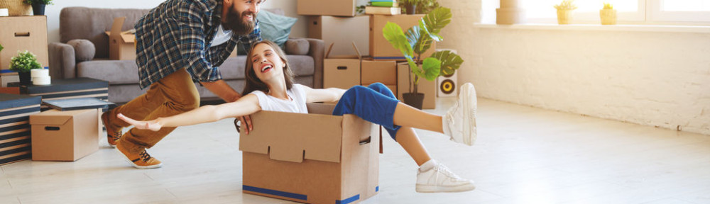 happy young married couple moves to new apartment