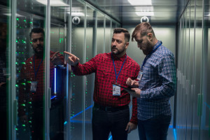 Adult bearded engineers in server room