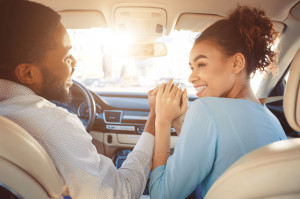 Travel by car. Happy african american couple holding hands