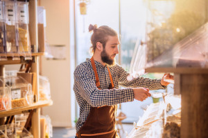 a seller in an organic food store filling bulk food containers