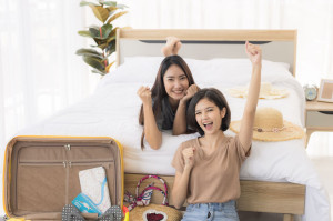 Two young asian women are using laptop to plan travel, book tick