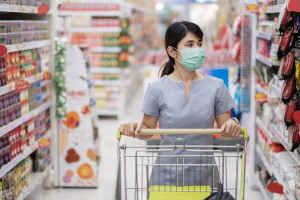 Young woman wearing protective face mask and  shopping in grocer