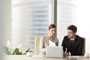 Female and male colleagues working with documents