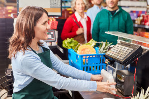 Cashier at checkout is using barcode scanner