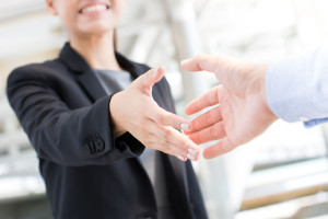 Young businesswoman going to make handshake with a businessman