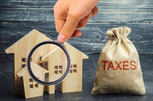 Bag with the money and the word Taxes and wooden houses. Taxes on real estate, payment. Penalty, arrears. Register of taxpayers for property. Law-abiding, evasion of payment. Court law. Luxury tax.