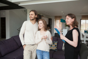 Realtor showing property for sale to young married couple