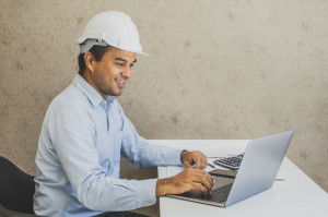 Asian civil engineer working planning project with laptop.