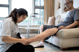 Asian daughter taking care of helping elderly,woman wear socks o