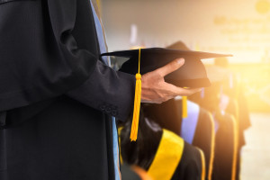 Graduates hold a congratulatory hat on campus.