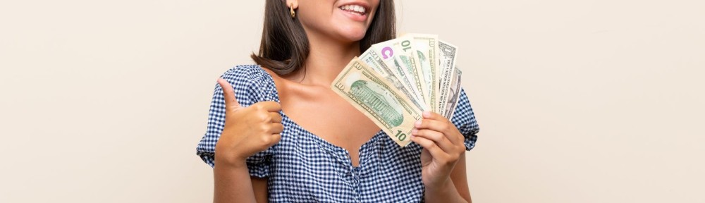 Young girl over isolated background taking a lot of money