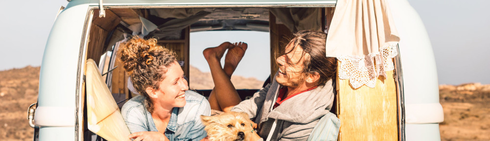 Hipster people with cute dog traveling together on vintage miniv