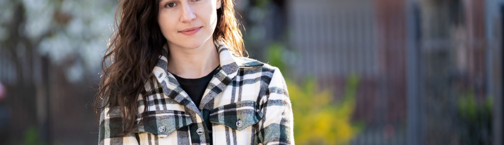 Portrait of thoughtful pretty young woman relaxing outdoors on warm spring sunny day