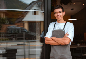 Young happy confident young man cafe or coffee shop owner being proud of his small business