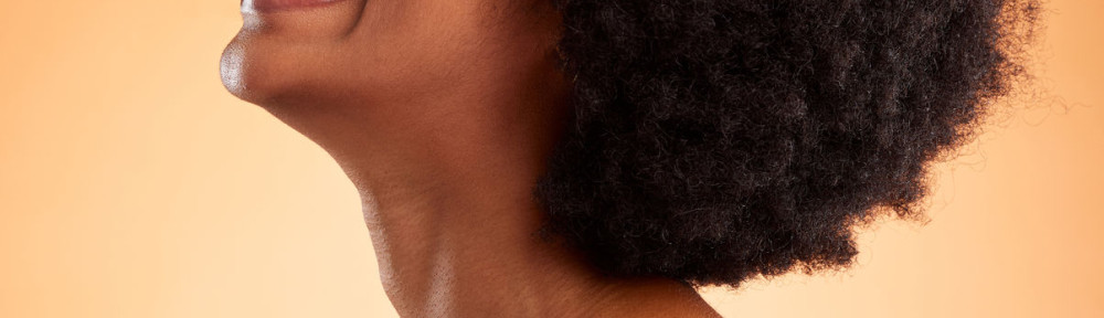 Cosmetics, black woman and smile with natural beauty with brown studio background being confident, happy and with afro. Makeup, female and African American girl being proud, laugh and clear skincare.