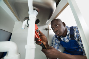 Handyman Repairing Sink Pipe