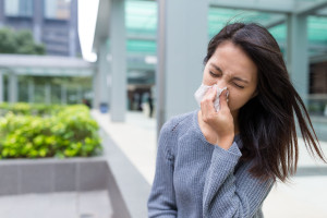 Woman feeling sick and sneezing