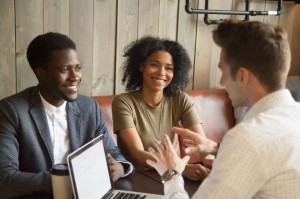 Caucasian architect consulting black clients out in coffee shop