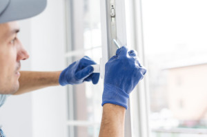 The worker installing and checking window in the house