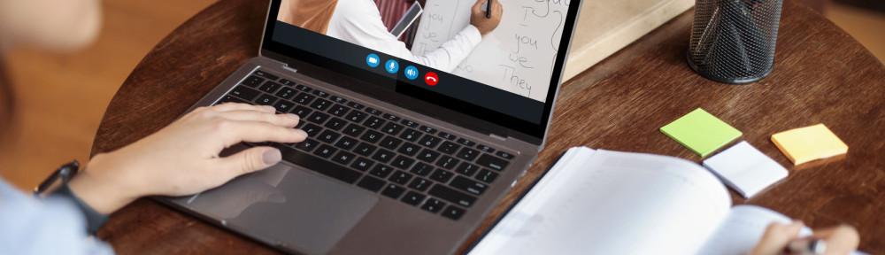 Woman sitting at desk using laptop, video chat with teacher