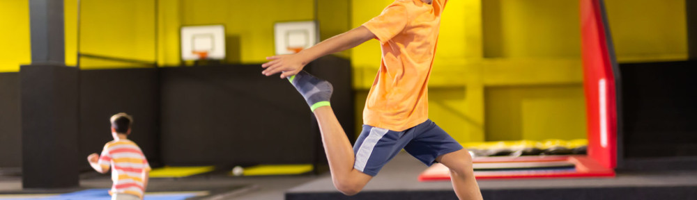 Preteen boy bouncing on trampoline in indoor amusement park