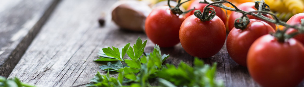 Fresh ingredients for cooking pasta, tomato and spices over wooden table background with copy space