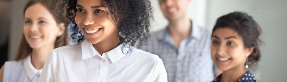 Excited multiracial team posing for group picture in office