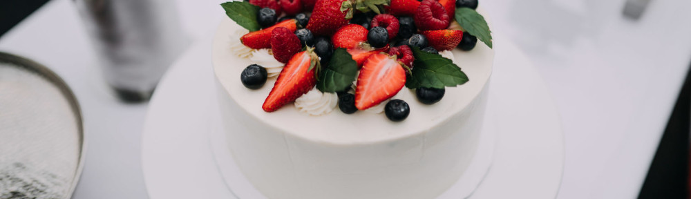 photo of white cake with strawberries on top