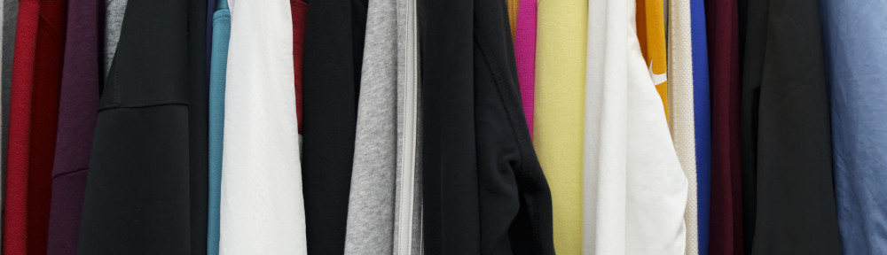 Second hand vintage clothes in a store on sale. Fashionable European used retro jeans, t-shirts, dresses, pants and accessories. Recycling and life extension for clothes concept.