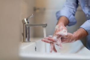 Man using soap and washing hands under the water tap. Hygiene concept hand closeup detail.